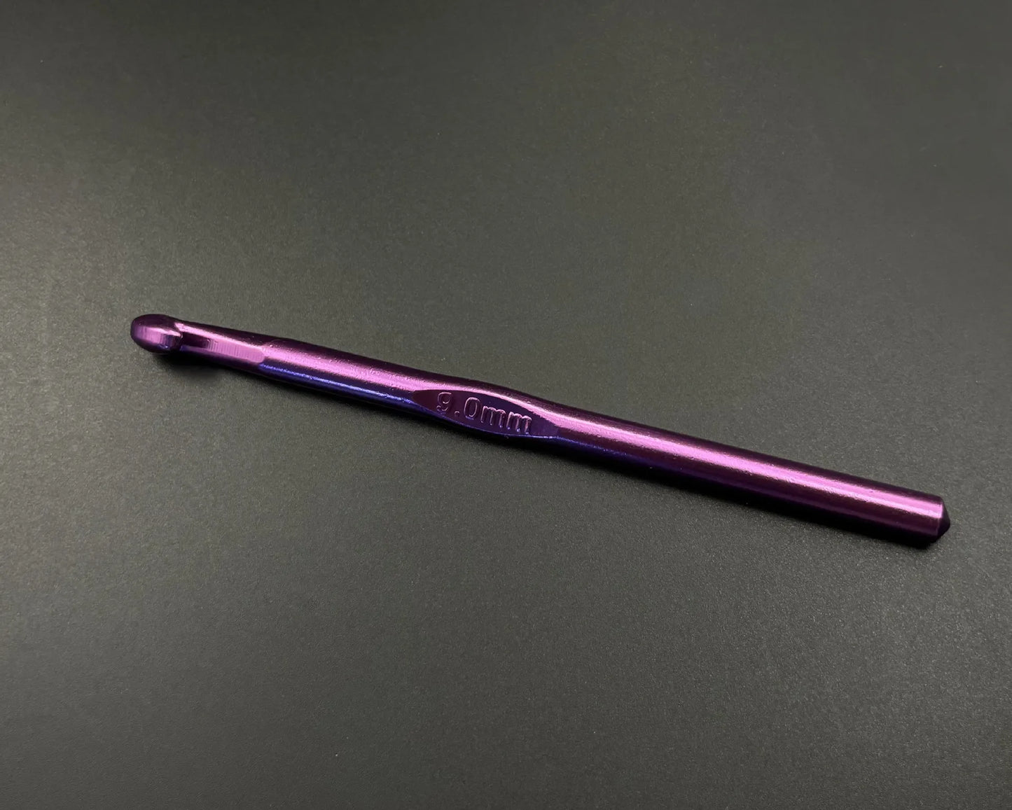 Purple 4.0mm crochet hook from rainbow aluminum crochet hooks set on black background