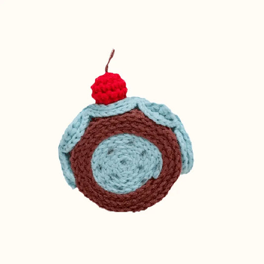 Realistic swiss roll crochet with brown and blue yarn topped with a red cherry by The Knit Krazy