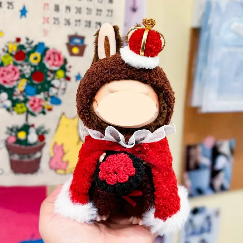 Hand holding a small plush doll wearing a royal king crochet pattern outfit with crown and red cape