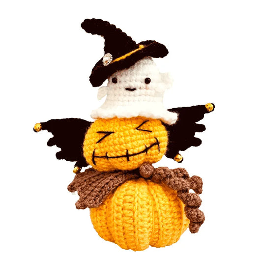 Crocheted pumpkin with ghost face and witch hat on a white background