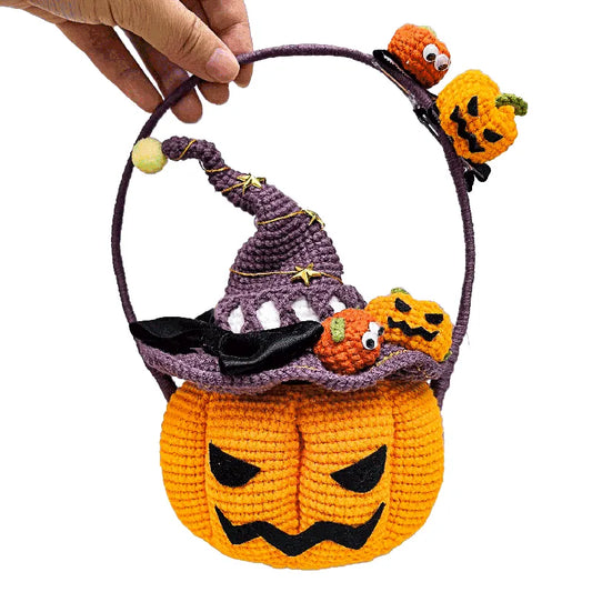 Handmade Halloween-themed crochet basket with pumpkins and a witch's hat on a white background.