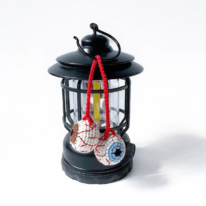 Black lantern with colorful hanging decorations on a white background