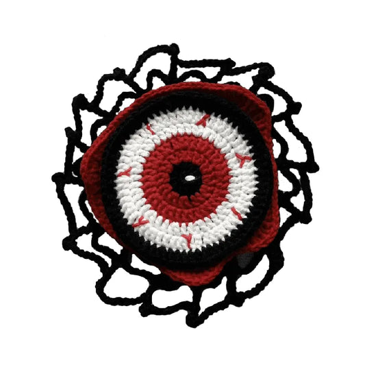Crocheted eye design with red, white, and black colors on a white background