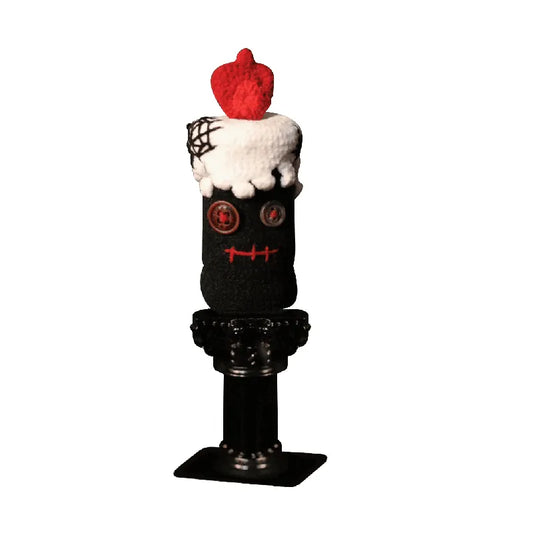 Decorative figure of a character with a black outfit, white cape, and red apple on a white background