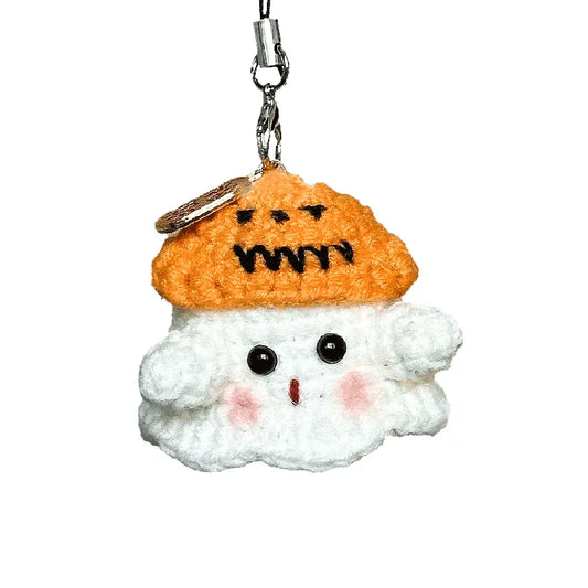Crocheted snowman keychain with pumpkin hat on a white background