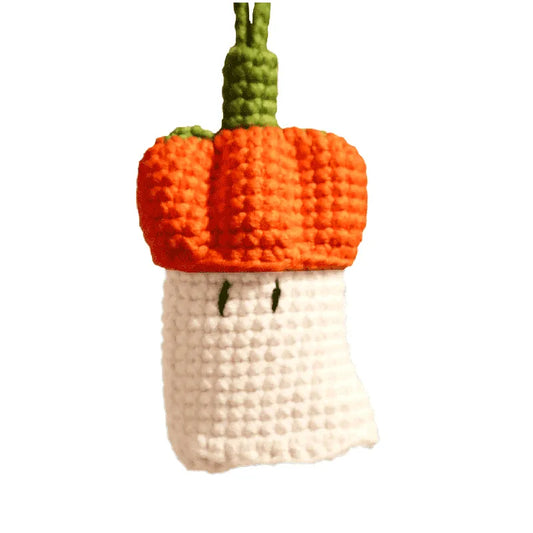 Crocheted pumpkin-shaped toy with a white base on a white background