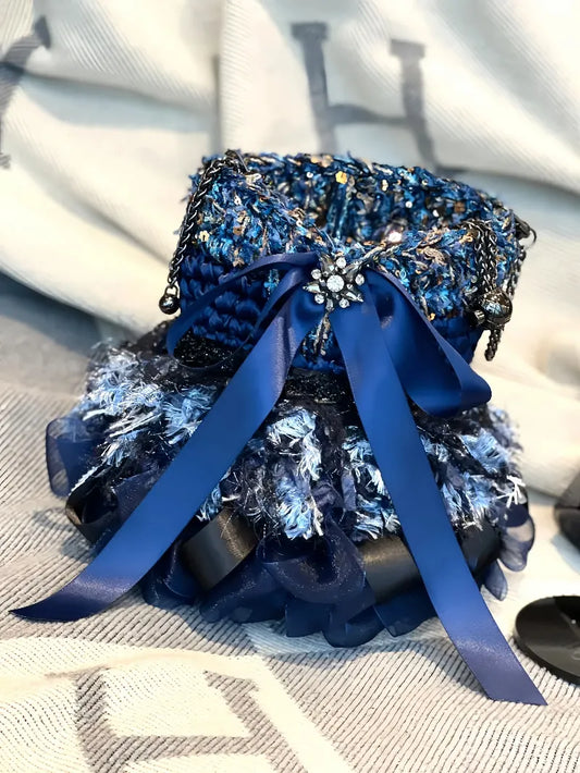 Blue crochet handbag pattern with textured yarn and decorative ribbon bow by redbook