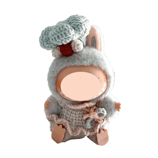 Handmade chef costume crochet pattern for dolls featuring a fluffy hat and detailed apron on a plush doll