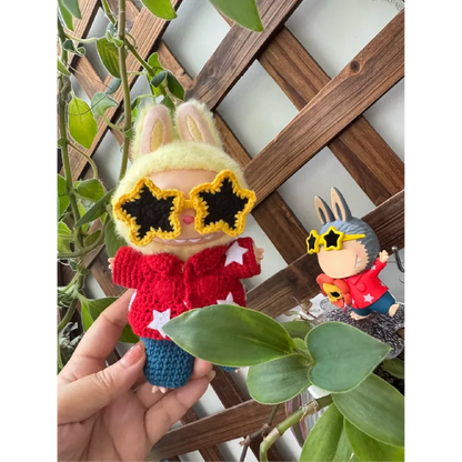 Collectible doll crochet design wearing yellow star-shaped sunglasses and a red hoodie with white stars