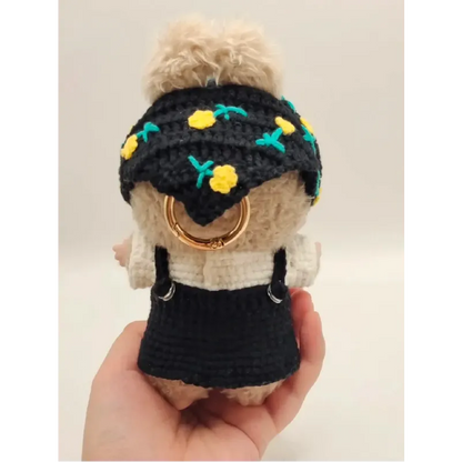 Collectible doll crochet outfit featuring a black skirt and floral headband with yellow flowers