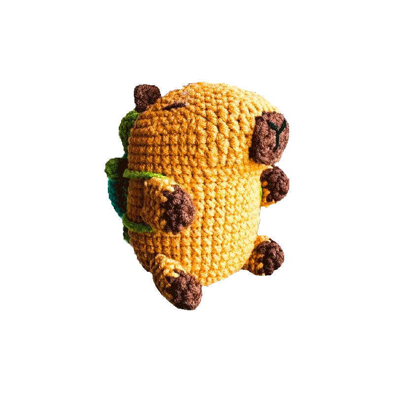 Handmade crochet capybara keychain pattern with brown and yellow yarn details on black background