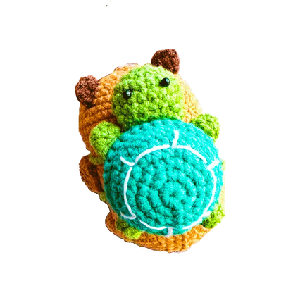 Handmade crochet capybara keychain pattern featuring a colorful green and orange stuffed animal with a blue shell