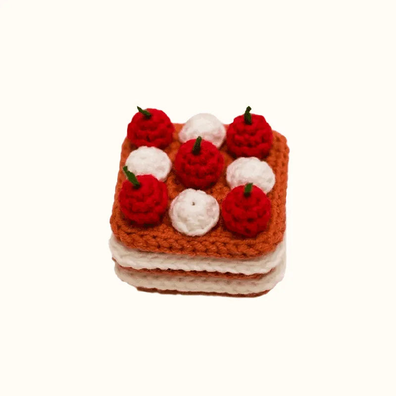 Handcrafted crochet cherry cake with red cherries and white cream using crochet cherry cake pattern