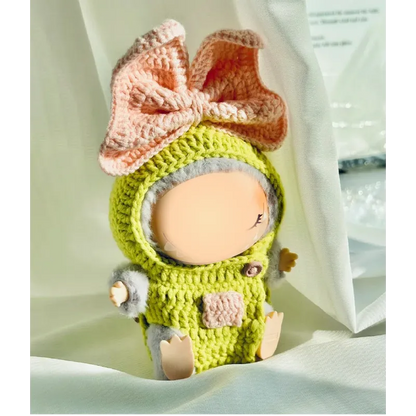 Cute crochet doll dressed in a green and pink crochet doll outfit pattern with a large bow