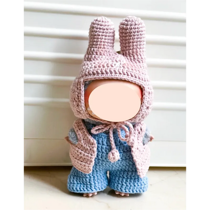 Handmade crochet doll wearing pink bunny ear hat and vest with blue pants from The Knit Krazy