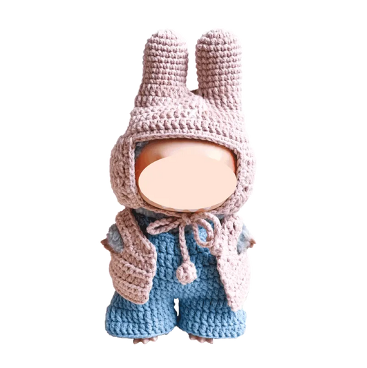 Handmade crochet baby doll wearing pink bunny hat and blue overalls by The Knit Krazy