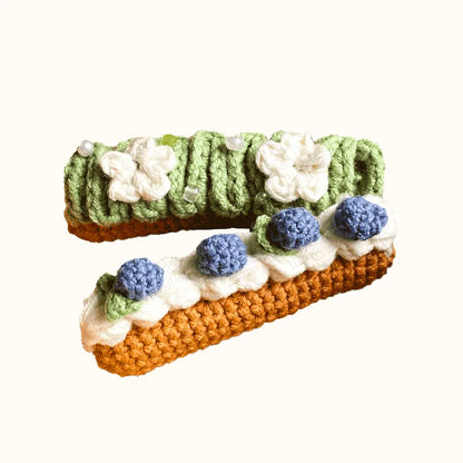 The Knit Krazy crochet eclair pattern beginner kit with green and brown crocheted eclairs decorated with blue and white flowers