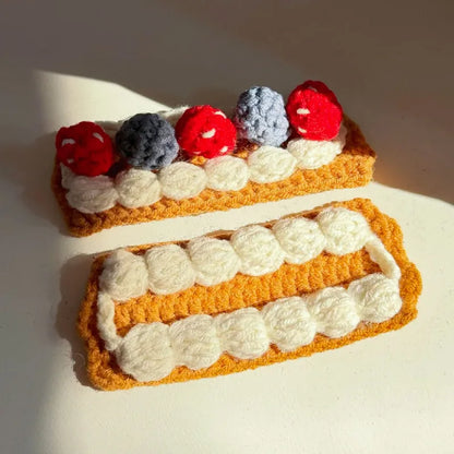 Handcrafted crochet Napoleon cake pattern featuring layered cream and berry decorations in vibrant colors