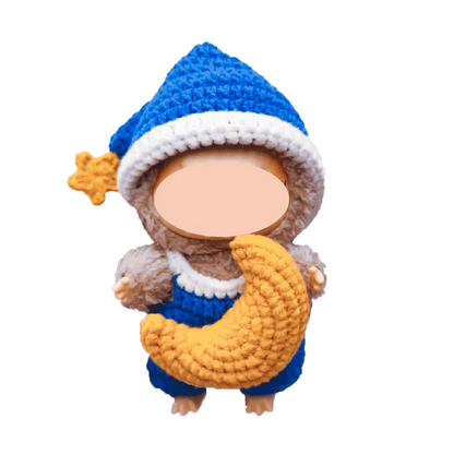 Handmade crochet doll wearing blue and white hat holding a yellow crescent moon plush