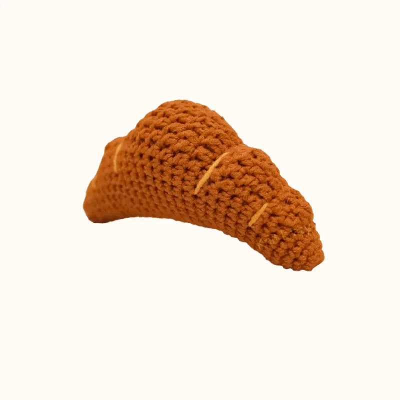 Brown crochet croissant shaped toy made using DIY crochet croissant pattern by The Knit Krazy