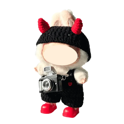 DIY crochet devil costume with red horns and black outfit on a plush figure holding a camera