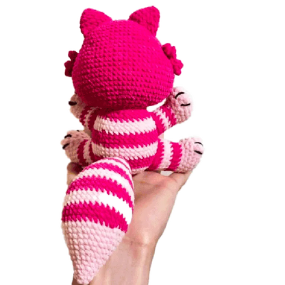 Hand holding a pink and white striped crocheted Cheshire cat using free crochet cheshire cat pattern
