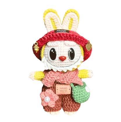 Handmade knitted bunny doll with red hat, pink scarf, green bag, and brown outfit by The Knit Krazy