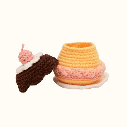Crochet caramel pudding pattern by The Knit Krazy featuring a yellow pudding with pink and white whipped cream and a chocolate topping with a cherry