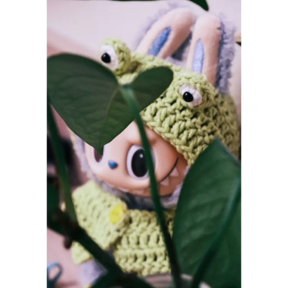 Cute bunny doll wearing a green frog knit doll outfit with big eyes knitted on the hood