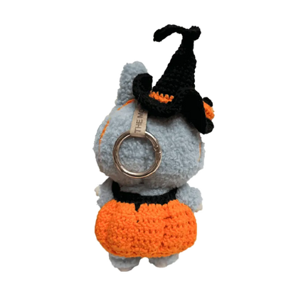 Cute doll wearing a handmade pumpkin costume pattern for dolls with an orange skirt and black witch hat