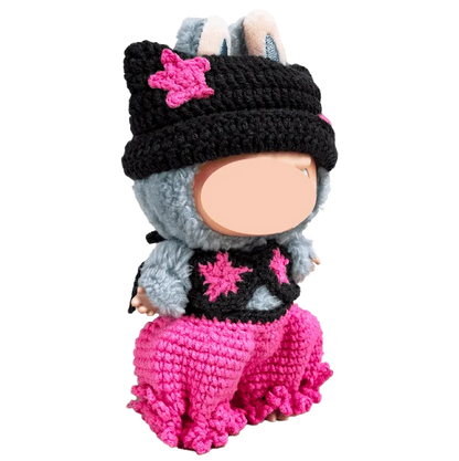 Handmade crocheted doll wearing pink pants and a black hat with pink star accents from The Knit Krazy