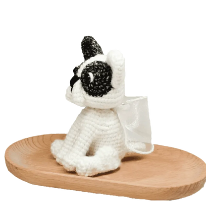 Handmade crochet French bulldog made with black and white yarn on a wooden tray crochet french bulldog pattern