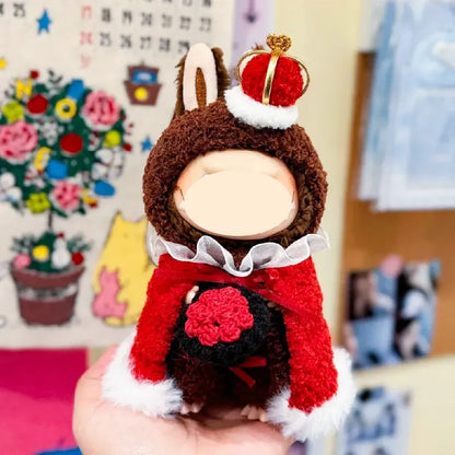 Hand holding a small plush doll wearing a royal king crochet pattern outfit with crown and red cape